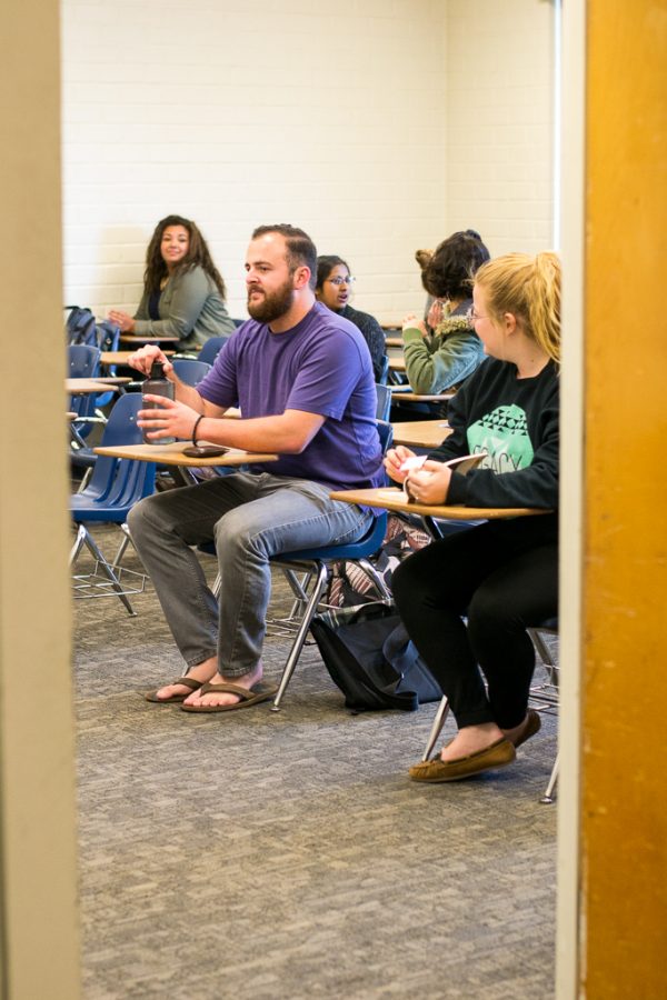 Junior Kyle Relph sits among scattered classmates and several empty desks in his ASL class. Professors like Biblical studies professor Jeff Volkmer try not to turn students away, but because of the cap, it happens often and students are put on waiting lists. | Ashleigh Fox/THE CHIMES