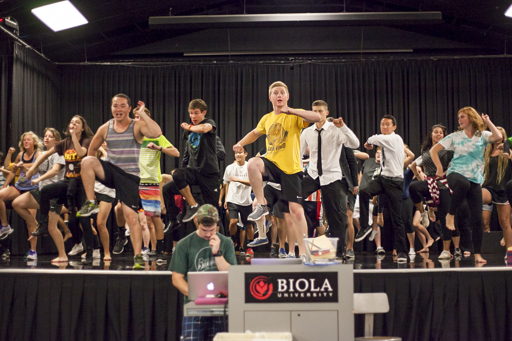 Freshman Zack Brisson leads the S.O.S. Mock Rock team during their practice in Mayers Auditorium. | Melanie Kim/THE CHIMES