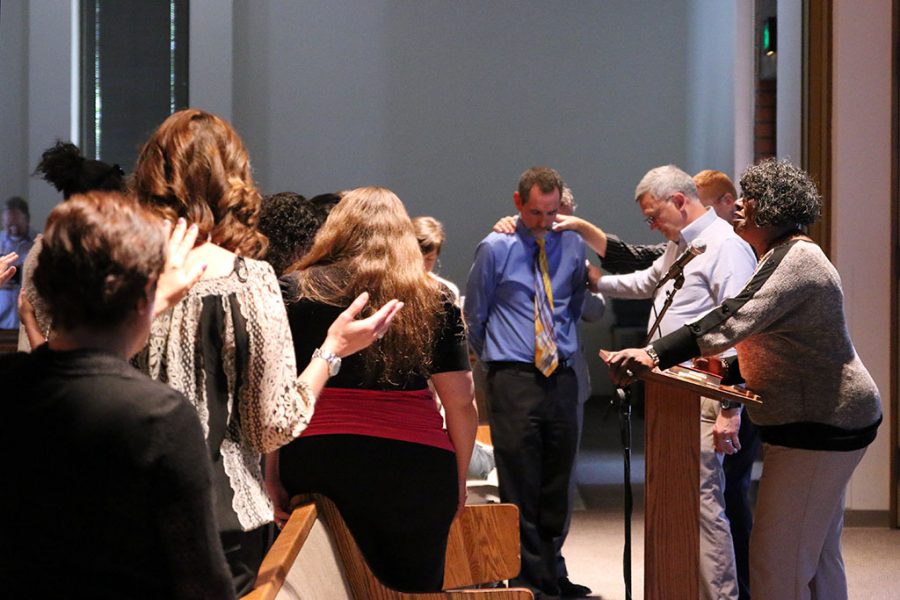 Biola staff prays over Geoff Marsh, director of financial aid, after April Jaces death was announced Tuesday afternoon. A service was held in Calvary Chapel to pray over the staff and Jaces family. | Aaron Fooks/THE CHIMES