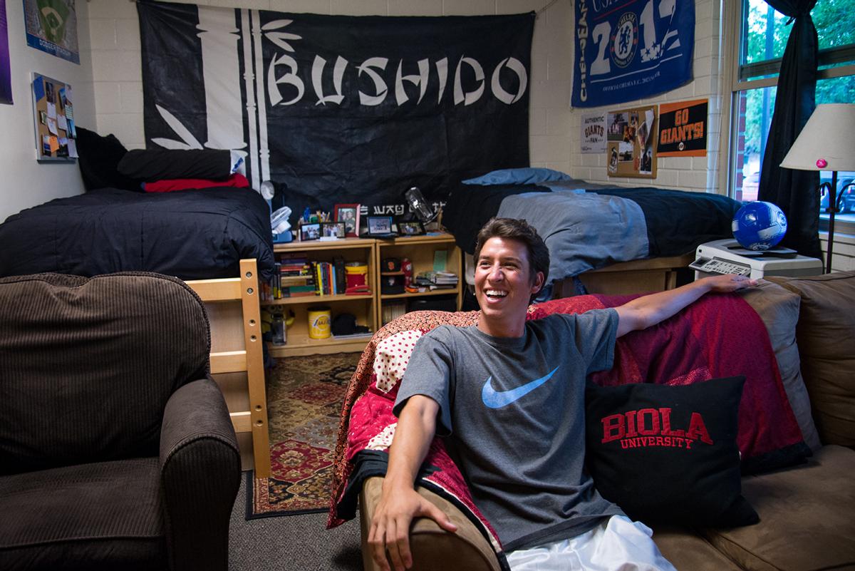 Junior Jon Blea explains the significance of the Bushido banner that covers his wall along with other decorations in his room, including the handmade pillow from his mother. | Jenny Oetzell/THE CHIMES