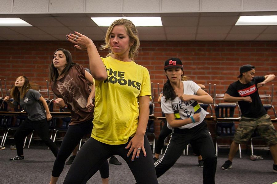 Freshman cinema and media arts major Maggie Gray dances with XOPOC members during a rehearsal. | Melanie Kim/THE CHIMES