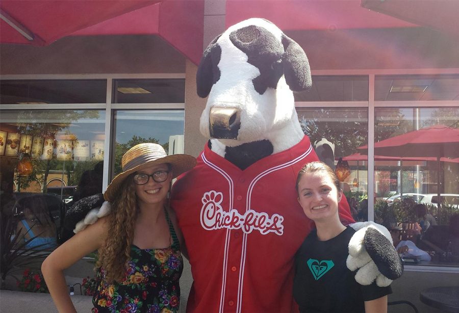 Freshman cinema and media arts major Sophia Johnson and English major Emily Martin stand with the iconic Chick-fil-A cow at a Torrientation lunch hosted by the La Habra restaurant. | Courtesy of Sophia Johnson