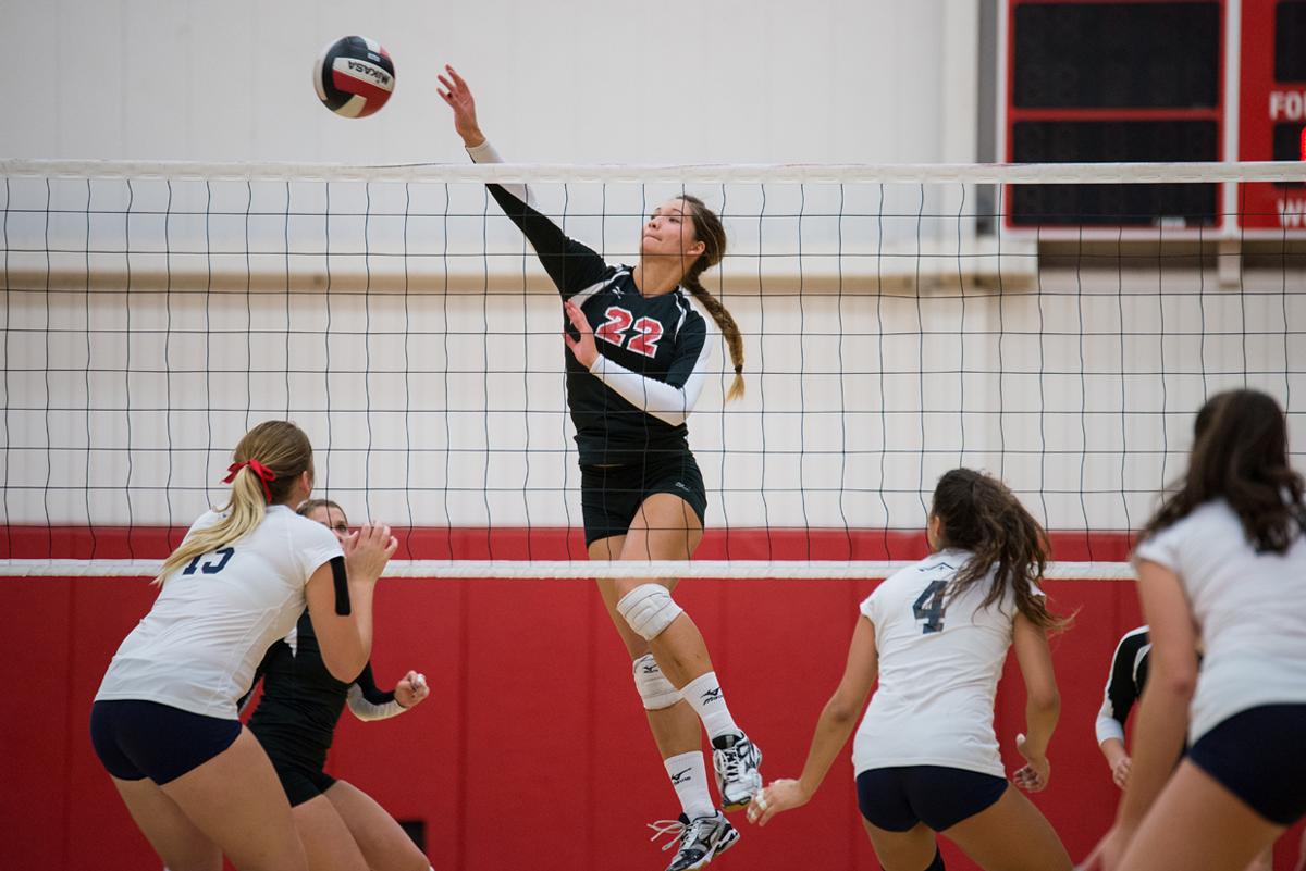 Junior middle blocker Lauren Hoenecke taps the ball over the net at the Sept 13 game against Hope International. | Jenny Oetzell/THE CHIMES