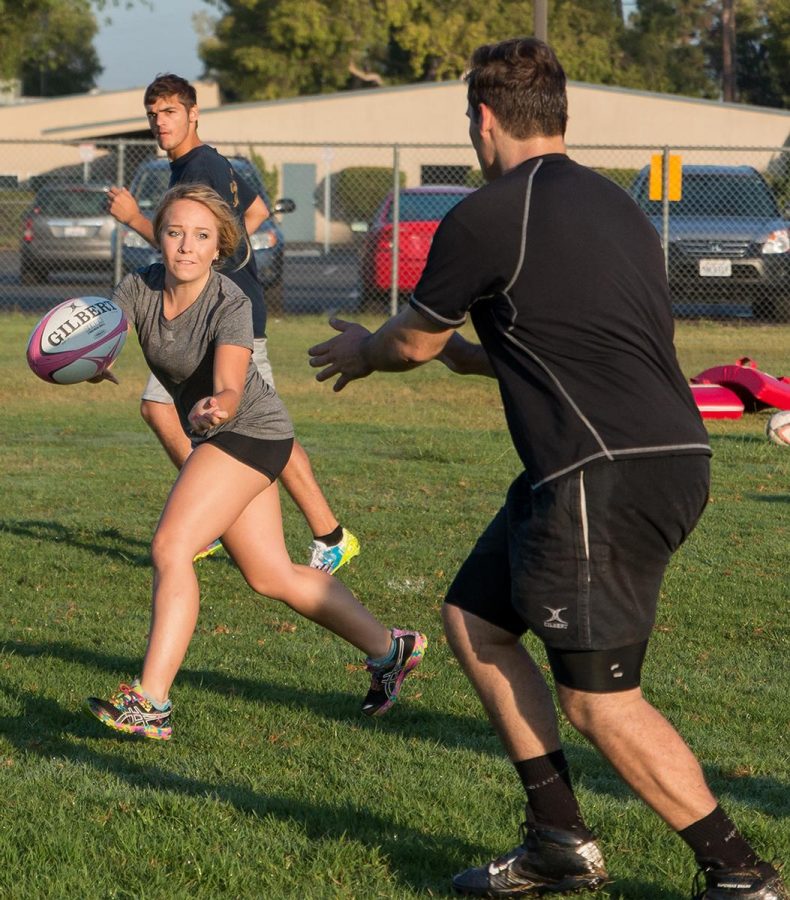 Junior Morgan Johnson catches the ball from a teammate during a morning rugby practice on McNally field. | Aaron Fooks/THE CHIMES