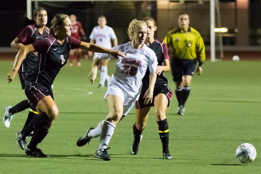 Junior foreword Brittney Sayre dribbles the ball past Westmont University players at the game on Sept. 30. | Molli Kaptein/THE CHIMES