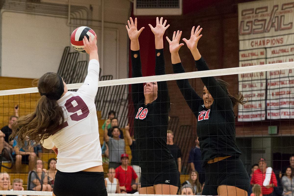 Senior middle blocker Amy Weststeyn and junior offensive hitter Joclyn Kirton jump to block a hit from Westmont College on Oct. 7. | Molli Kaptein/THE CHIMES