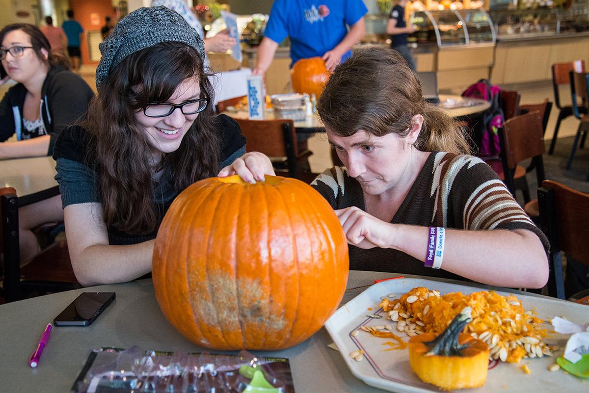 Senior art majors Haley Martin and Melinda Kaun participate in the pumpkin carving contest held at Café Biola on Oct. 23. | Jenny Oetzell/THE CHIMES