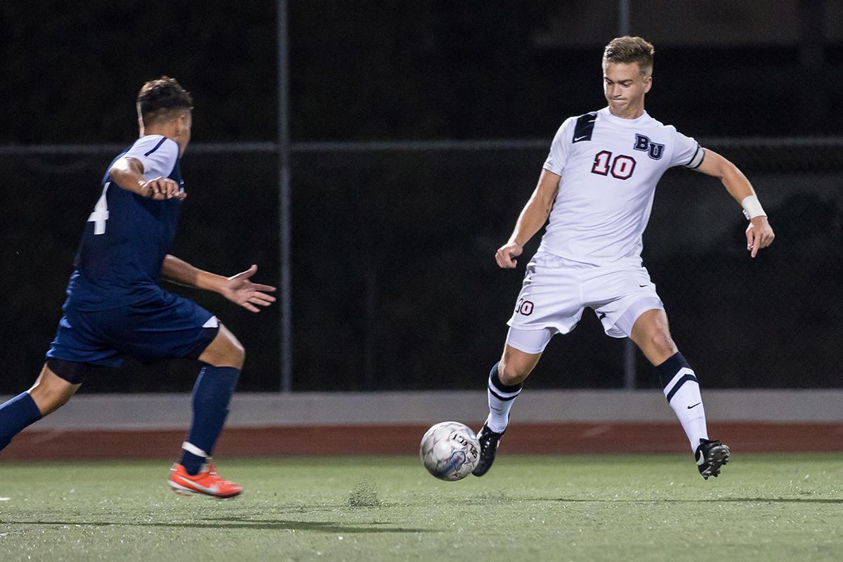 Junior midfielder Joey O'Keefe passes the ball at the game against Vanguard on Oct. 18. | Marika Adamopoulos/THE CHIMES