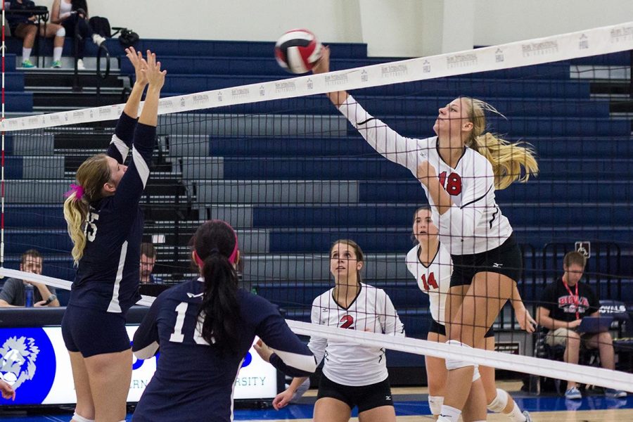 Senior middle blocker Amy Weststeyn spikes the ball against Hope International on Oct. 11. | Jenny Oetzell/THE CHIMES [file photo]