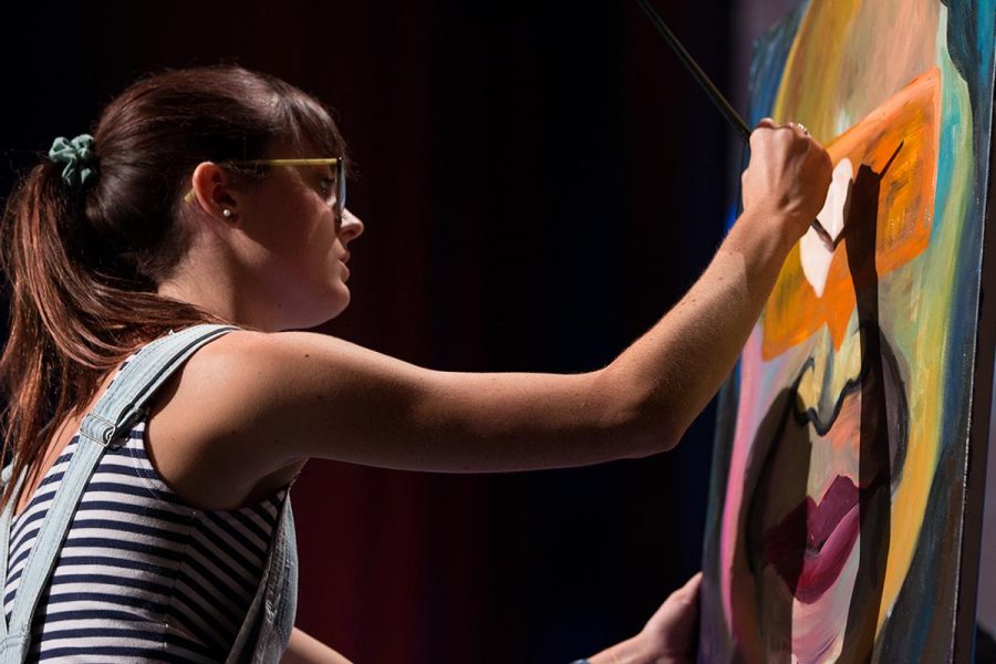 Biola alumna Kearci Moir painted on stage while each person spoke at the final session of the first day of Torrey Conference 2014. | Karen Jensen/THE CHIMES