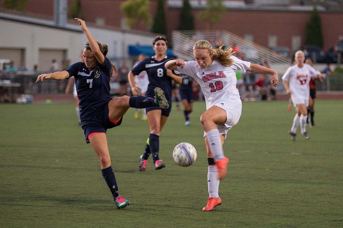 Senior Brittany Beam of San Diego Christian College shys away from a kick by sophomore midfielder Jessie Burns on Oct. 22. | Katie Evensen/THE CHIMES