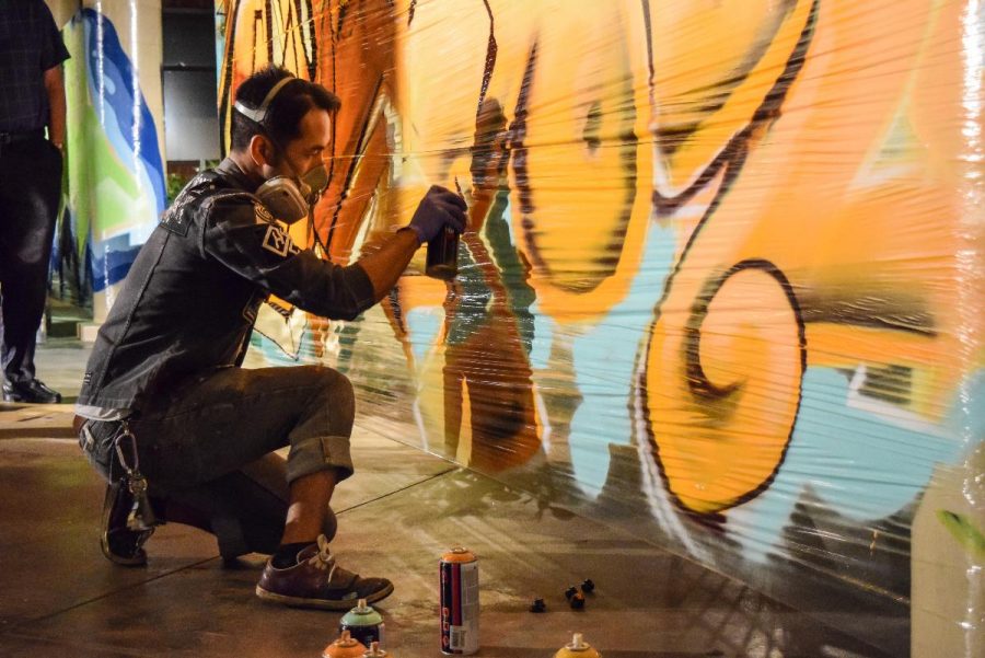 A graffiti artist creates a mural at Sola Soul 2014 which took place at Sutherland Auditorium. | Michelle Shin/THE CHIMES