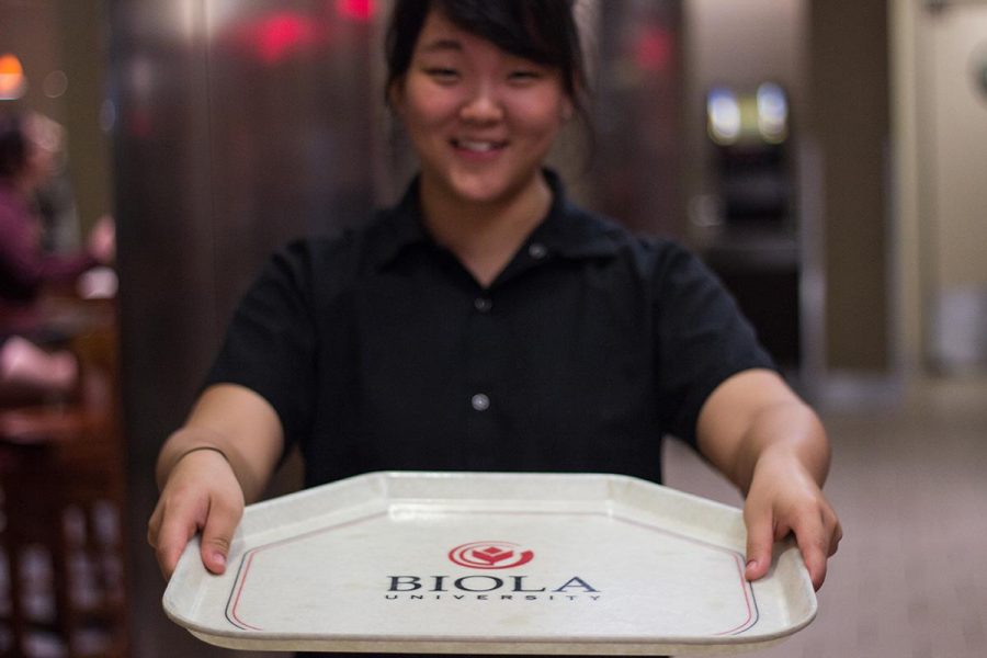 Junior pre-health care professional major Christina Chin holds up a tray at the Biola Café.  | Johnathan Burkhardt/THE CHIMES 