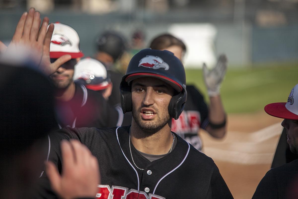 Senior Andrew Smith reaching for a highfive after hitting a 3 run home run. | Aaron Fooks/THE CHIMES