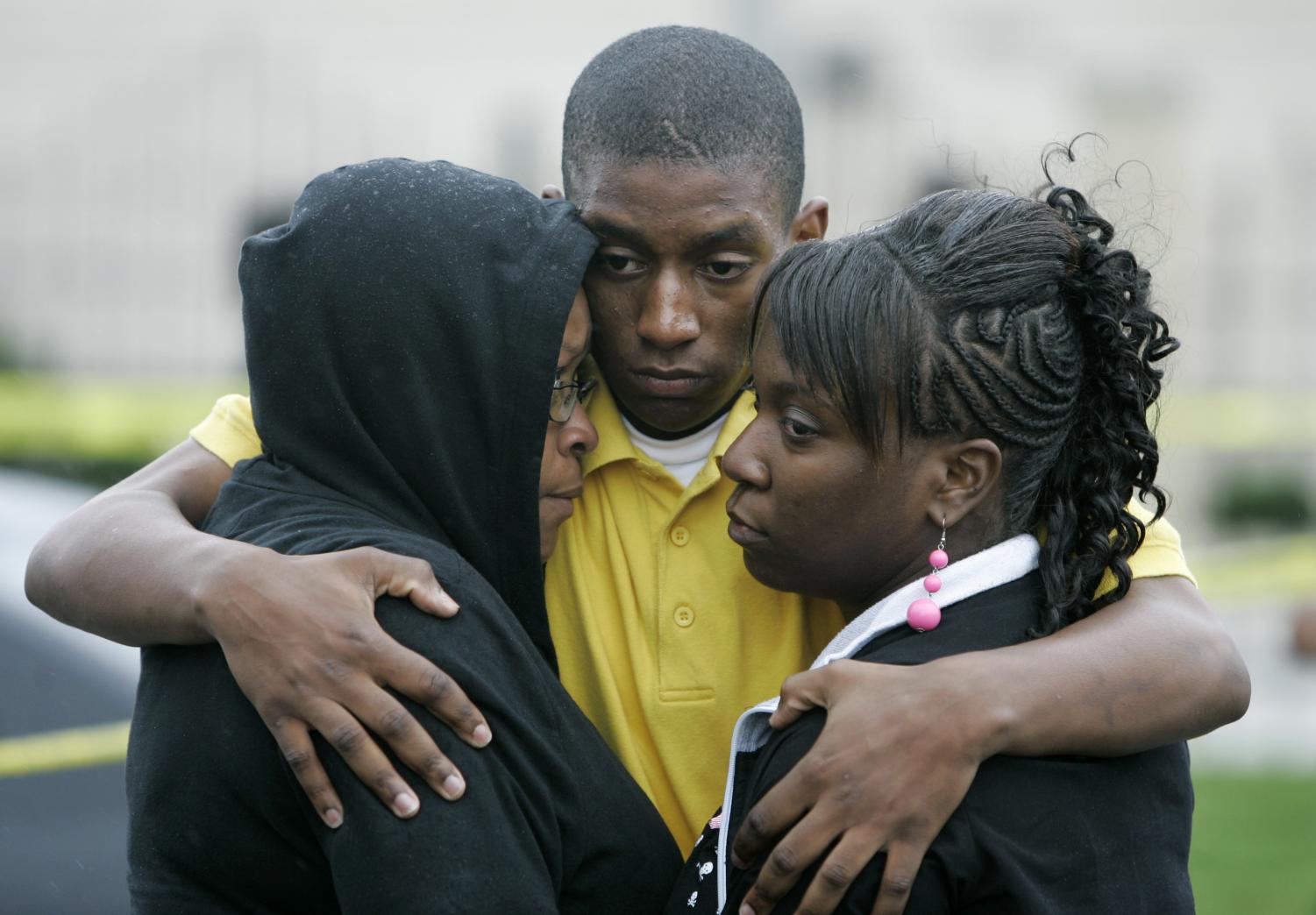 Family members hug outside the SuccessTech Academy Wednesday, Oct. 10, 2007, in Cleveland.