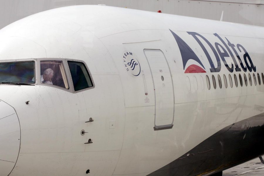 A pilot in a Delta Airlines jet sits in the cockpit in Seattle in this June 2, 2005 file photo. The airline introduced a humorous set of videos coaching passengers on plane etiquette.