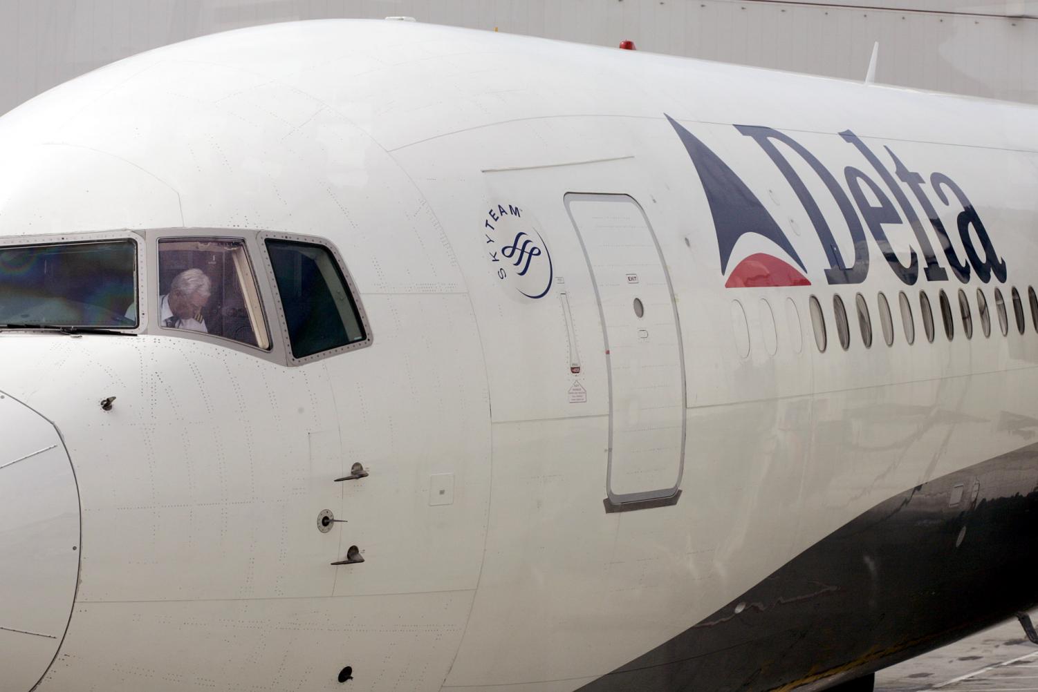 A pilot in a Delta Airlines jet sits in the cockpit in Seattle in this June 2, 2005 file photo. The airline introduced a humorous set of videos coaching passengers on plane etiquette.