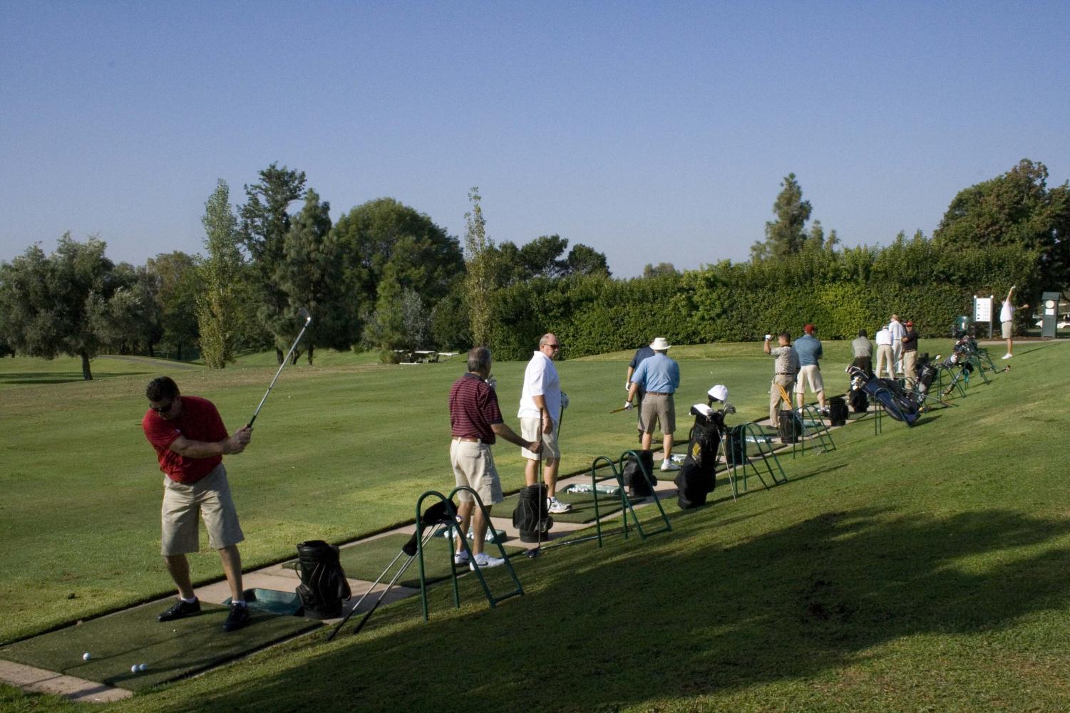 Golfers practice at the driving range before the 29th annual Biola Golf Tournament, a fundraiser.