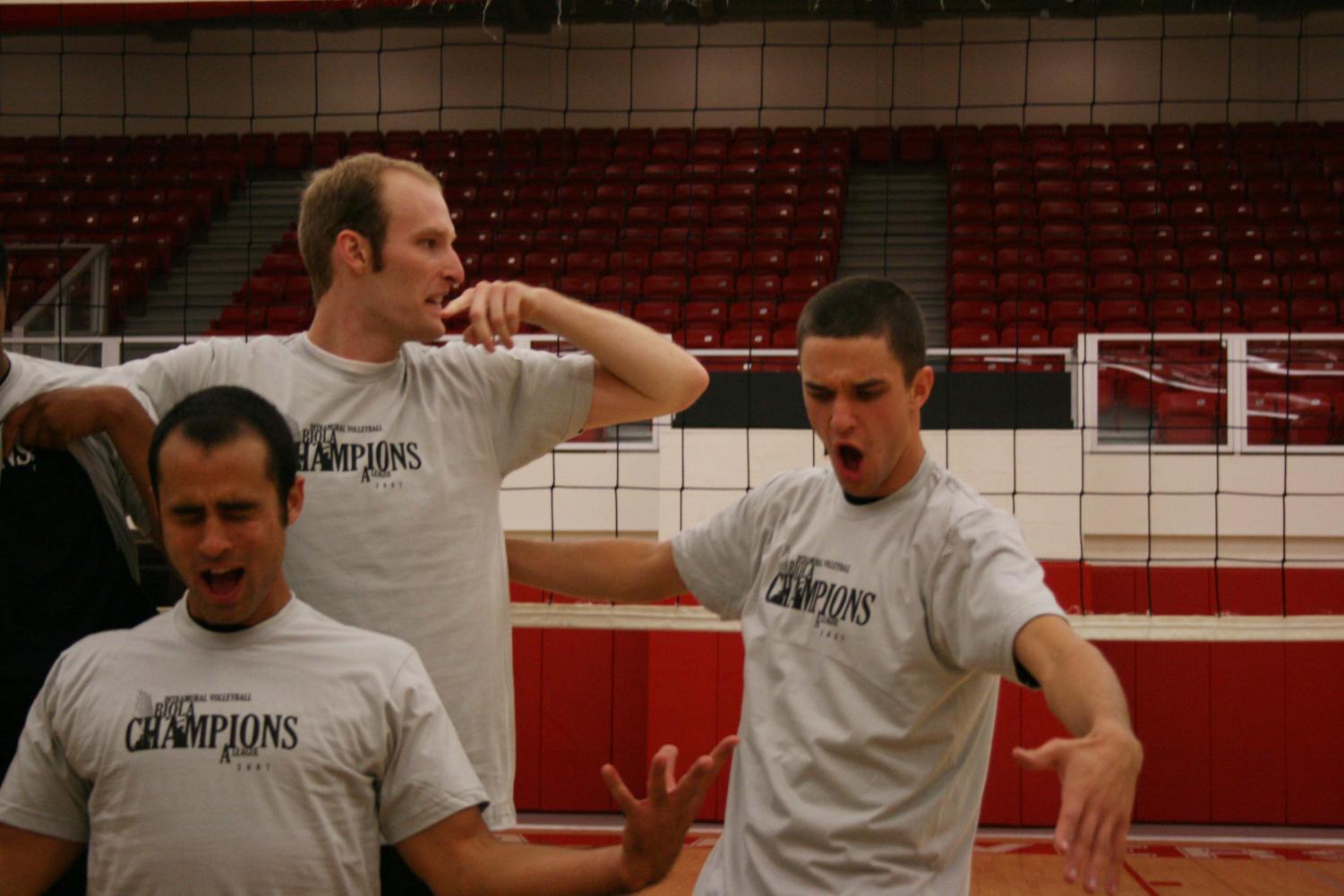 Johnny Tibbles, Kevin Cram, and Tyler Groenink soak up their victory after donning Champion t-shirts Friday night. Lil' Bit O' Color won in the A league volleyball playoff match in their second game.