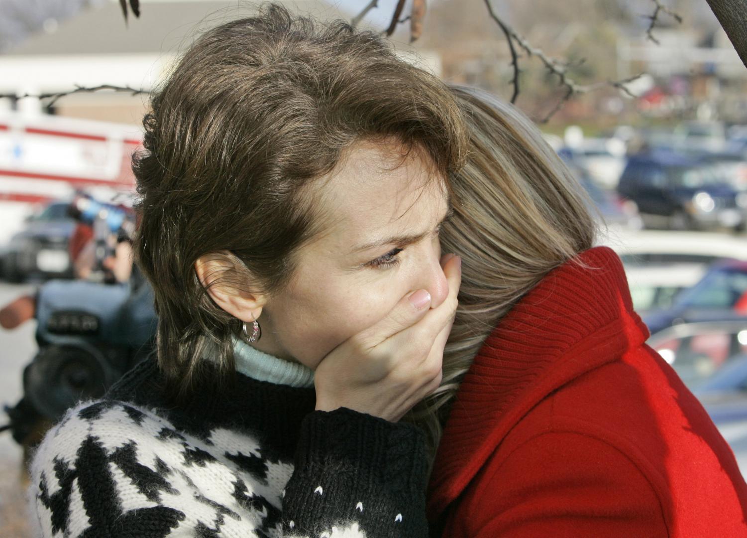 Larissa Starchenko, an employee who was inside the Von Maur store when a gunman opened fire, is comforted by her daughter Yara, back, in Omaha, Neb., Wednesday, Dec. 5, 2007. Police locked down the Westroads mall in Omaha after nine people were shot dead Wednesday afternoon.