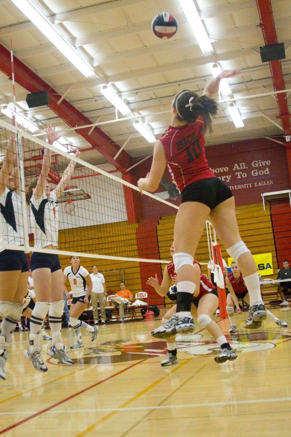 Outside hitter Kelsey Mitchell (10) slams the ball over the net. Biola finished its first season soaring over rivals Azusa Pacific University with a win 3-0 Tuesday.