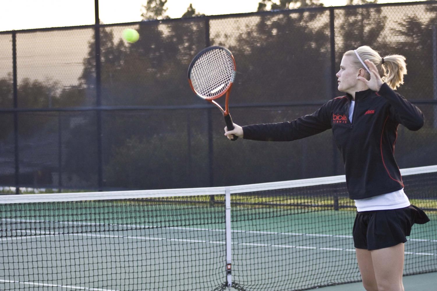 Freshman Sarah Snyder shows aggression at the net in her doubles match against the opposing team from the University of La Verne.