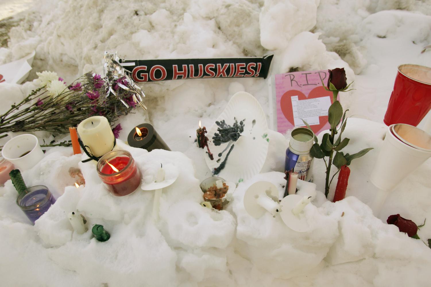 Flowers, candles, and small notes sit in the snow Friday, Feb. 15, 2008, on the campus of Northern Illinois University near Cole Hall, the scene where a lone gunman shot and killed six Thursday on the NIU in DeKalb, Ill.