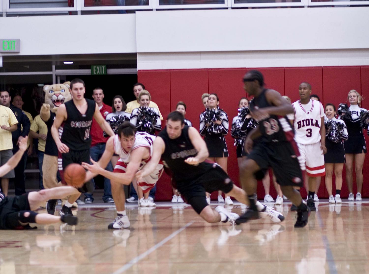 Sophomore Rocky Hampton dodges the APU players during last week's victory over Azusa Pacific University. Hampton led Biola with 25 points during their last game at Concordia University. The team lost their GSAC playoff game 67-71.