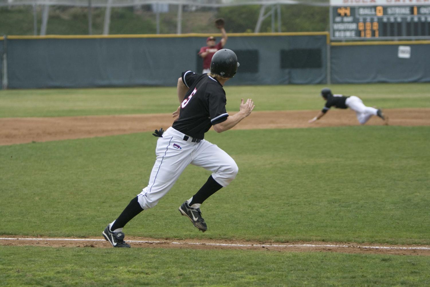 Junior infielder Hawkins Gebbers sprints to first base while watching his teammate slide in to second. Biola scored three in the bottom of the ninth forcing extra innings and resulting in a 11-9 victory.