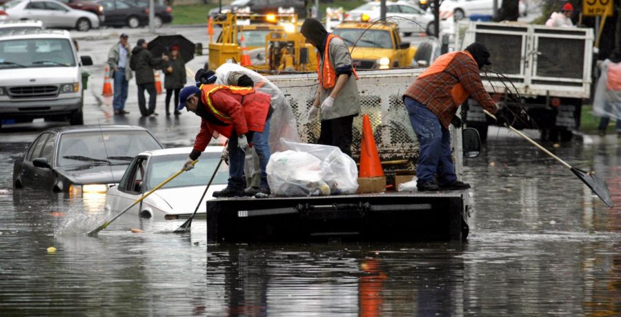 City workers retrieve debris from around a couple of partially submerged cars abandoned by their drivers in the Hancock Park section of Los Angeles Friday, Jan. 25, 2008. A powerful winter storm that unleashed a thick blanket of mountain snow, heavy rain and at least one tornado pounded Southern California for a fifth straight day Friday.
