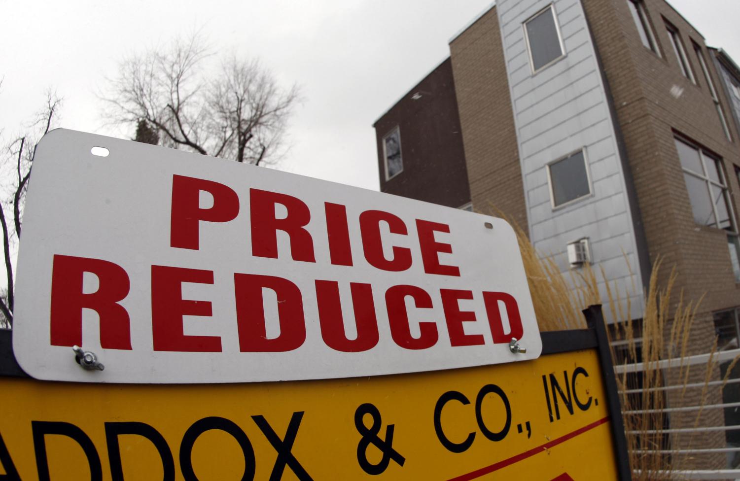 A price reduction sign tops the placard for an existing home on the market in south Denver on Sunday, Feb. 17, 2008. Sales of existing homes fell to the lowest level in nearly a decade in January while the median price for a home dropped for the fifth straight month.