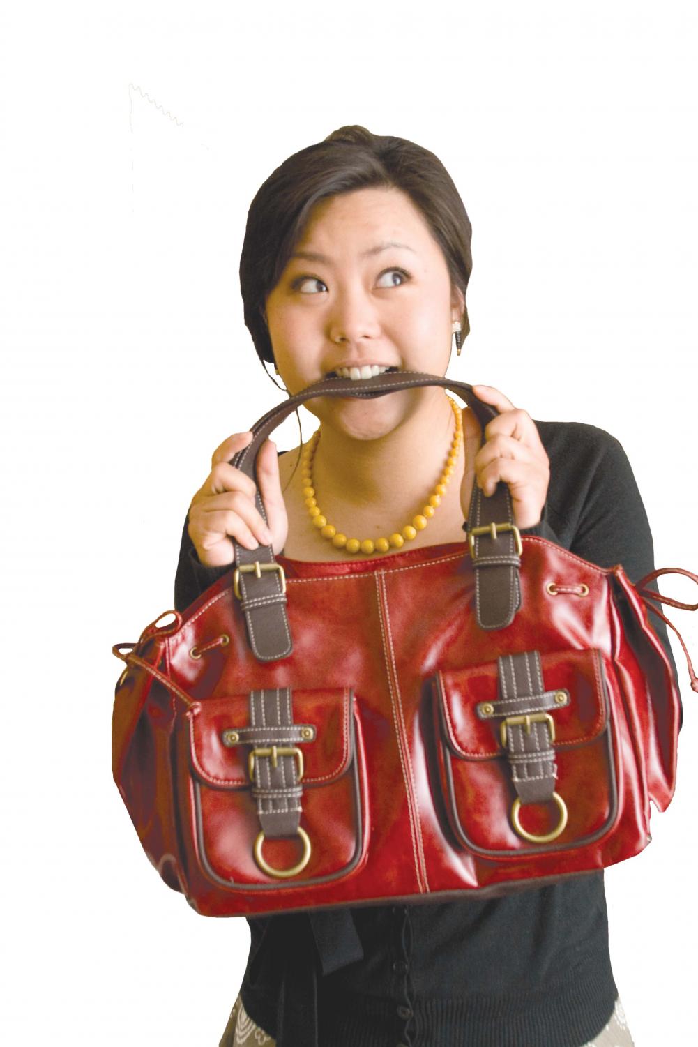 Tiffany Garner, senior, proudly shows off her red bag that she has correctly paired with a neutral outfit.