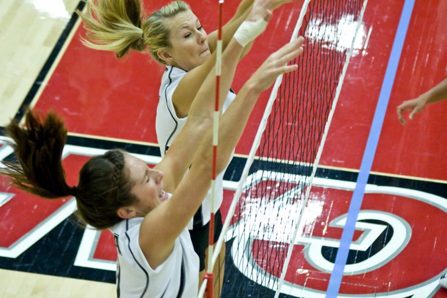 Kristen Peterson (top) and Kelsey Mitchell fight to block the opponent hit.