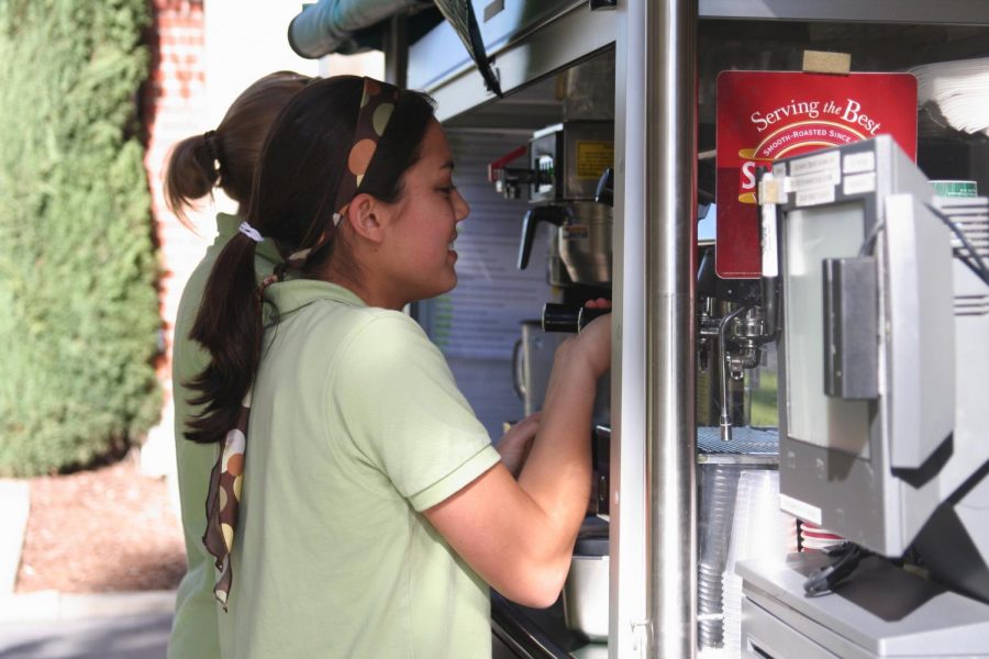 Sophomore, Elizabeth Vaughan, prepares a latte while working at the coffee cart outside Sutherland Hall.