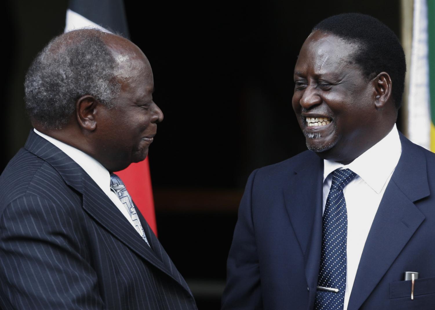 Kenyan President Mwai Kibaki, left, and opposition leader Raila Odinga, react, after signing a power-sharing agreement in Nairobi, Kenya, Thursday, Feb. 28, 2008, after weeks of bitter negotiations on how to end the country's deadly post election crisis. Both claim to have won the country's Dec. 27 presidential election, which observers say was marred by rigging on both sides.