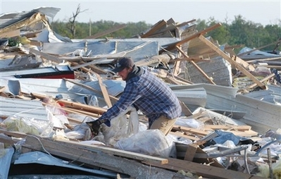 Craig Lant picks through the rubble of his parents businesses on Sunday morning, May 11, 2008 in Seneca, Mo. Craig's father, Bill Lant owned Lant's Feed Store and his mother, Jane, owned Lant's Bridal Garden located north of Seneca, Mo. Both businesses were destroyed by a tornado that swept through southwest Missouri late Saturday afternoon killing 12 people.