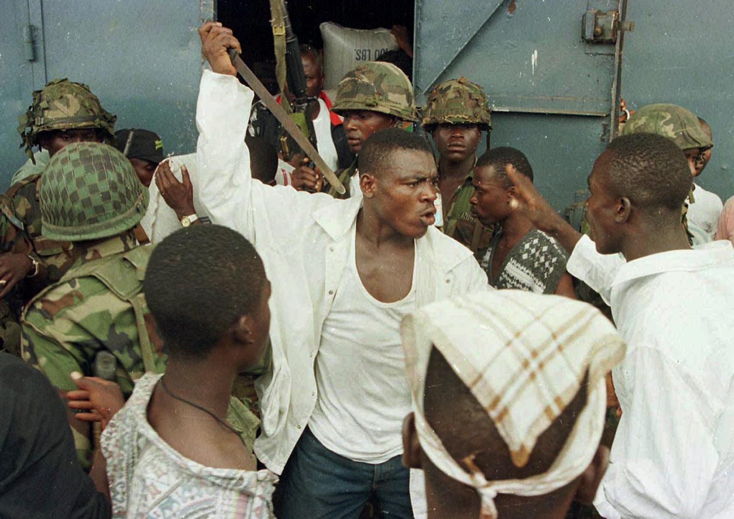 Joshua Milton Blahyi, a former Liberian factional fighter known as 'General Butt Naked' threatens a fellow combatant with a knife during an argument outside the Barclay Training Center army barracks in Monrovia, Liberia during fighting in the city in this May 15, 1996 photo. Blahyi, who is now an evangelist and a church pastor, earned his nom de guerre from his practice of storming into battle without a stitch of clothing, a move intended to terrify the enemy.