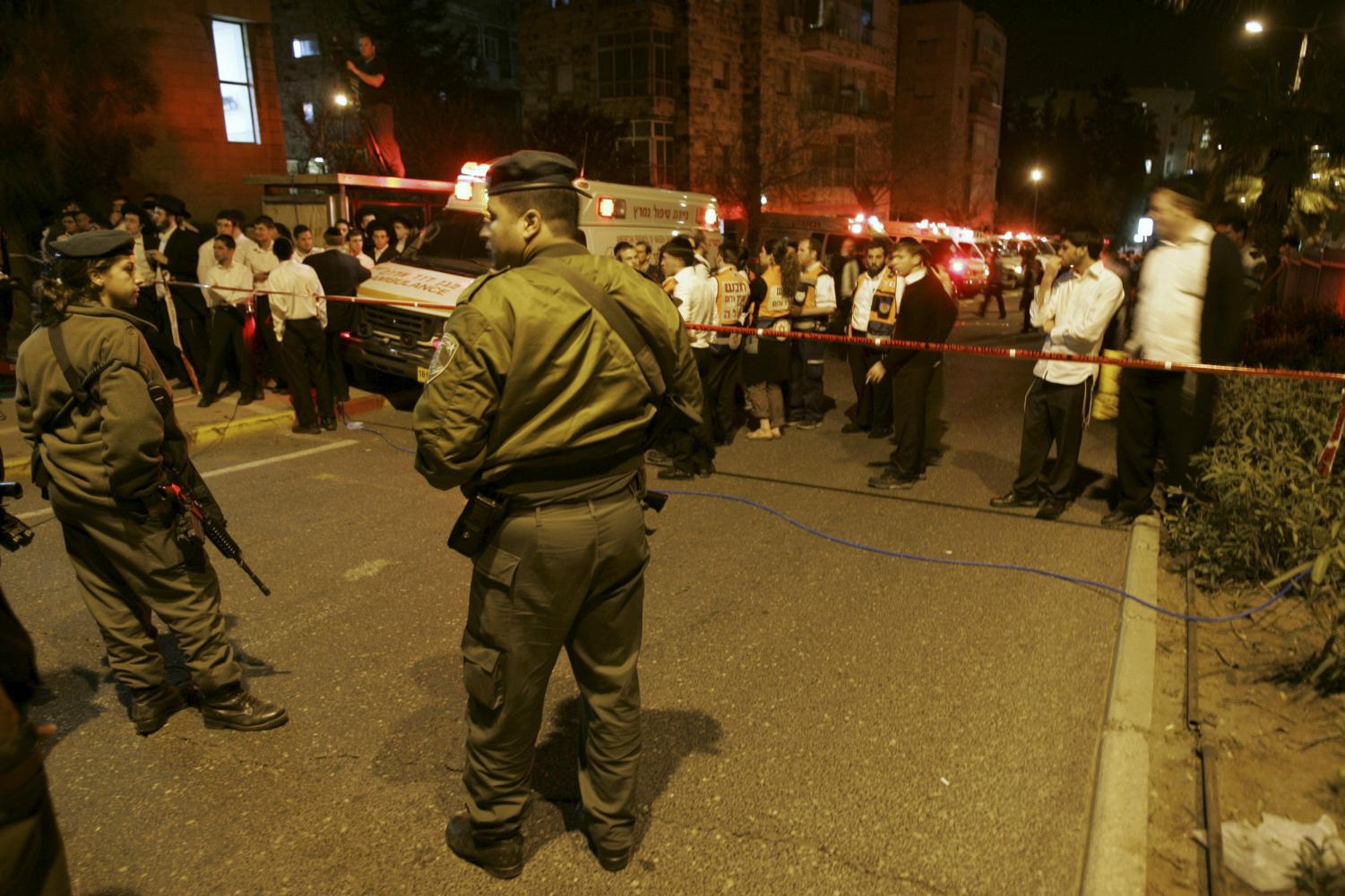 Israeli border police officers secure the area next to the site of a shooting attack at Mercaz Harav yeshiva in Jerusalem, Thursday, March 1, 2008. A gunman entered the library of a rabbinical seminary and opened fire on a crowded nighttime study session Thursday, killing seven people and wounding dozens of others before he was killed, police and rescue workers said. It was the first militant attack in Jerusalem in more than four years.