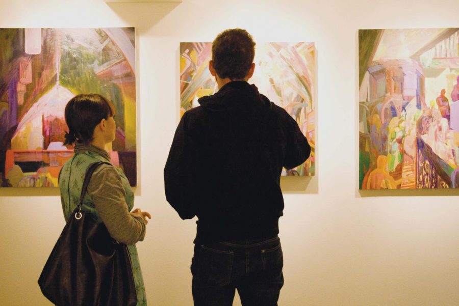 Students admire the work of Biola alumni during the last art show of the semester before the senior show begins.