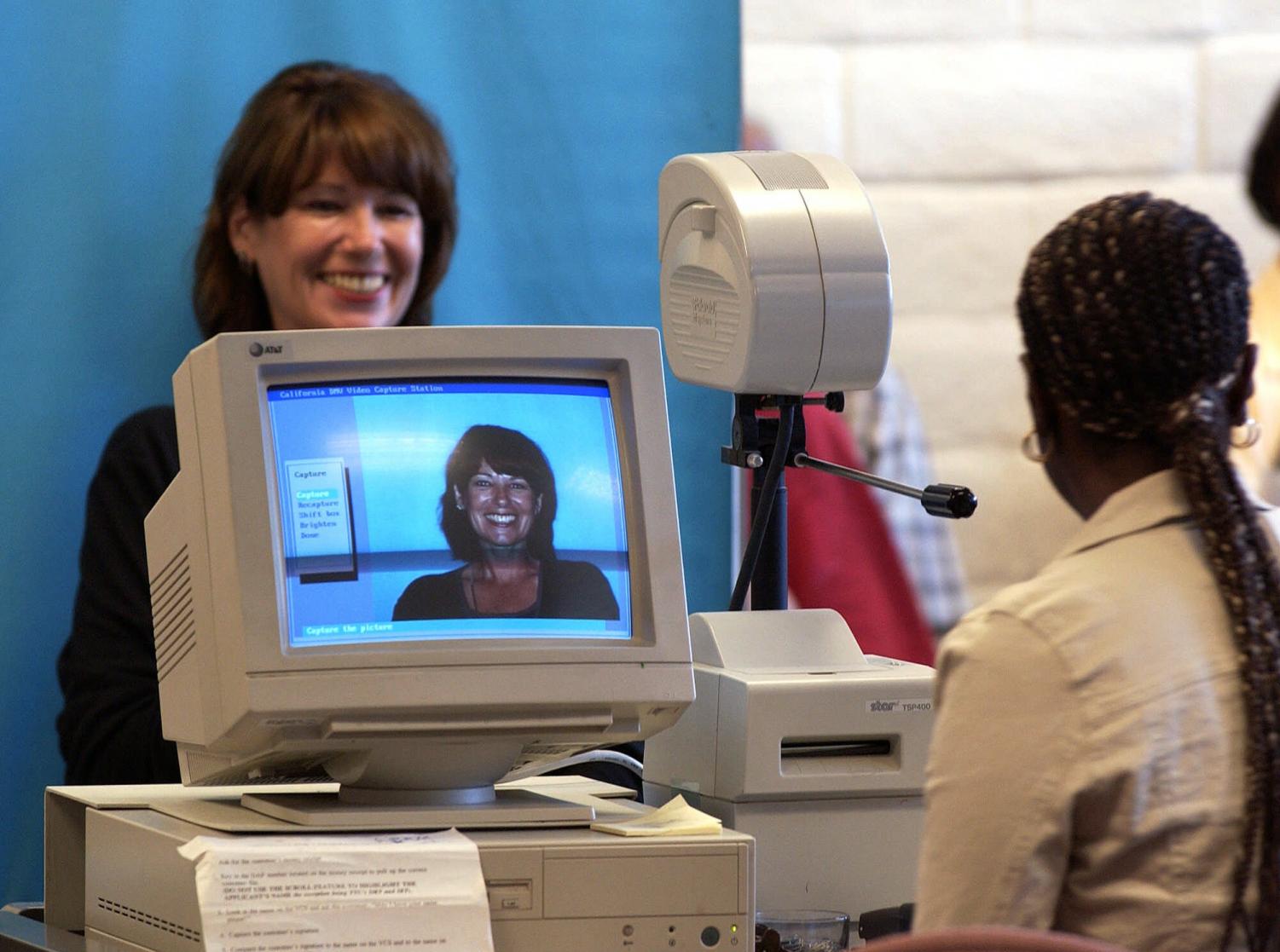 A woman has her photo taken by an unidentified DMV technician at the California Department of Motor Vehicles office in San Diego in this 2001 file photo.