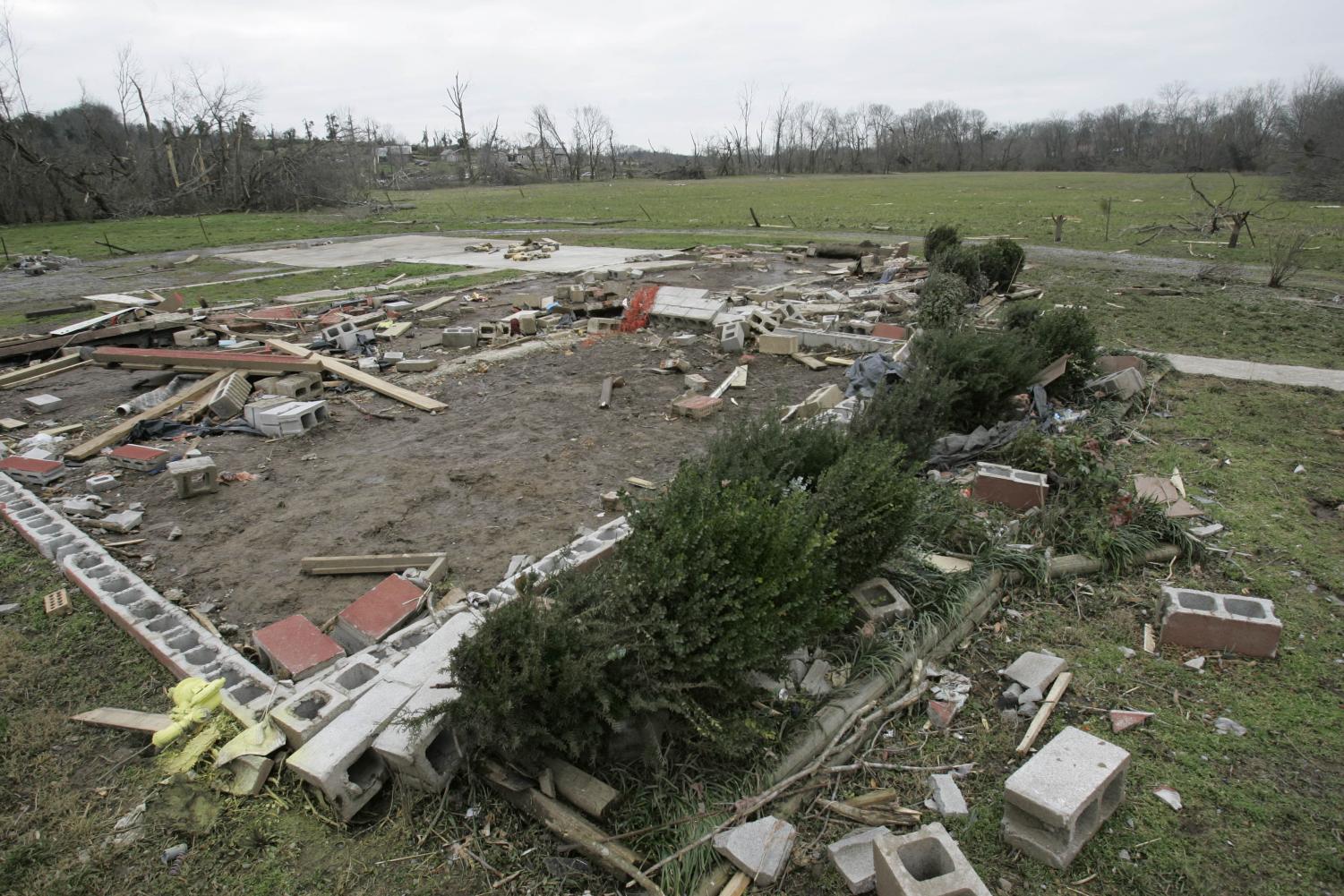The wreckage of a home is seen next to an open field Thursday, Feb. 7, 2008 in Castalian Springs, Tenn. A baby was found alive in the field, shown in center background, Wednesday after the tornado destroyed the home where the baby was believed to be living.