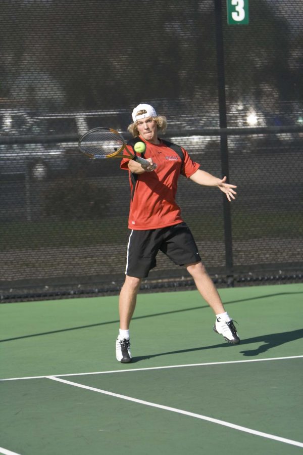 Freshman Daniel Westman swings hard o return a serve from the opposing team. Westman won his personal match by a score of 6-1.