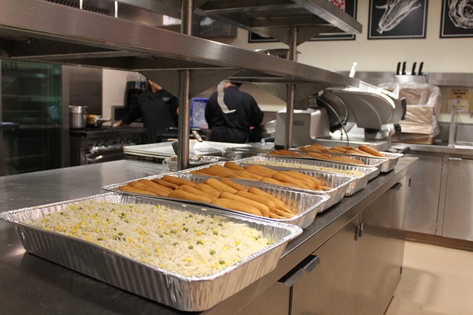 Five trays of food wait in the Caf kitchen.