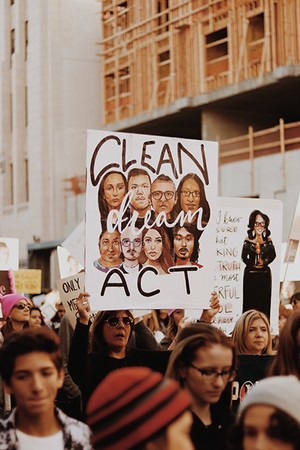 A woman holding a sign calling for a clean Dream act during a march.