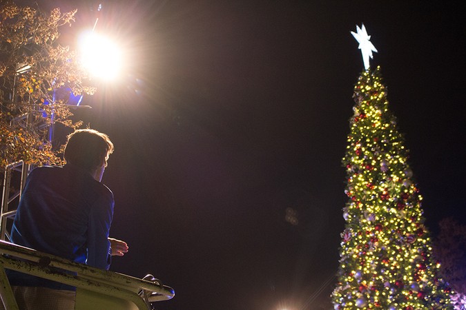 An Event Services worker looks up at the lit Christmas Tree star while preparing for the annual lighting.