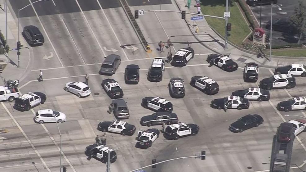 An aerial shot of several police vehicles waiting at an intersection.