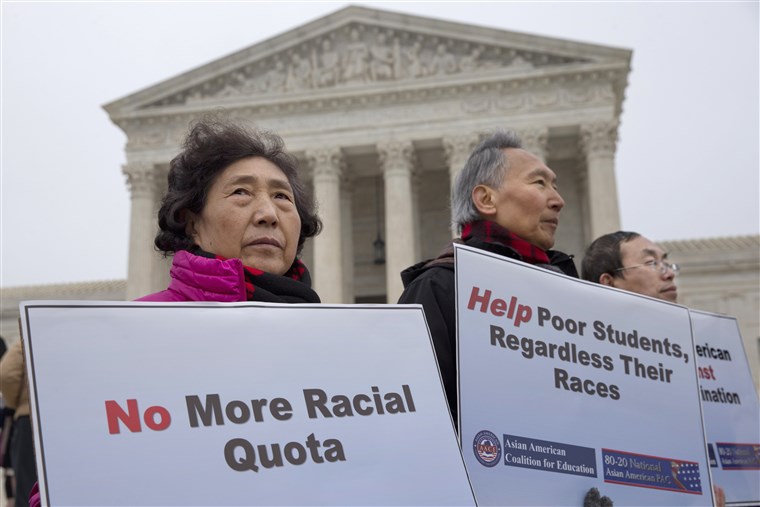 Three Asian-American protesters hold signs: No More Racial Quota Help poor students, regardless their races