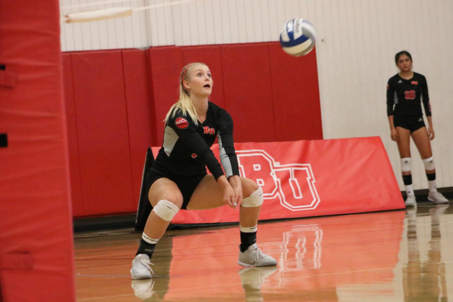 Senior digs a ball out during the Eagles' volleyball game