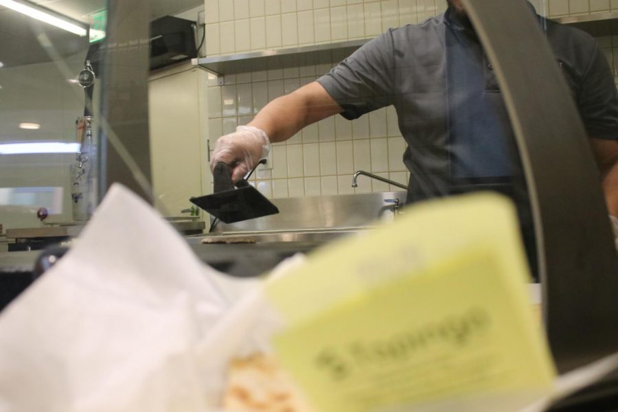 Photo depicts a Blackstone Cafe Worker cooking on the hotplate.