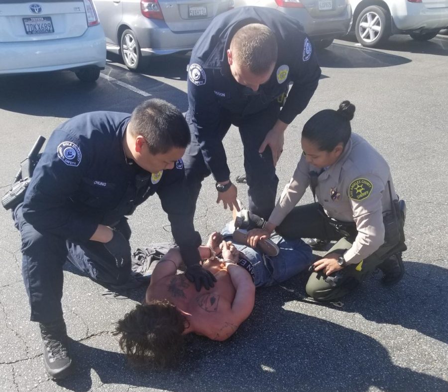 three officers restrain a man on the ground